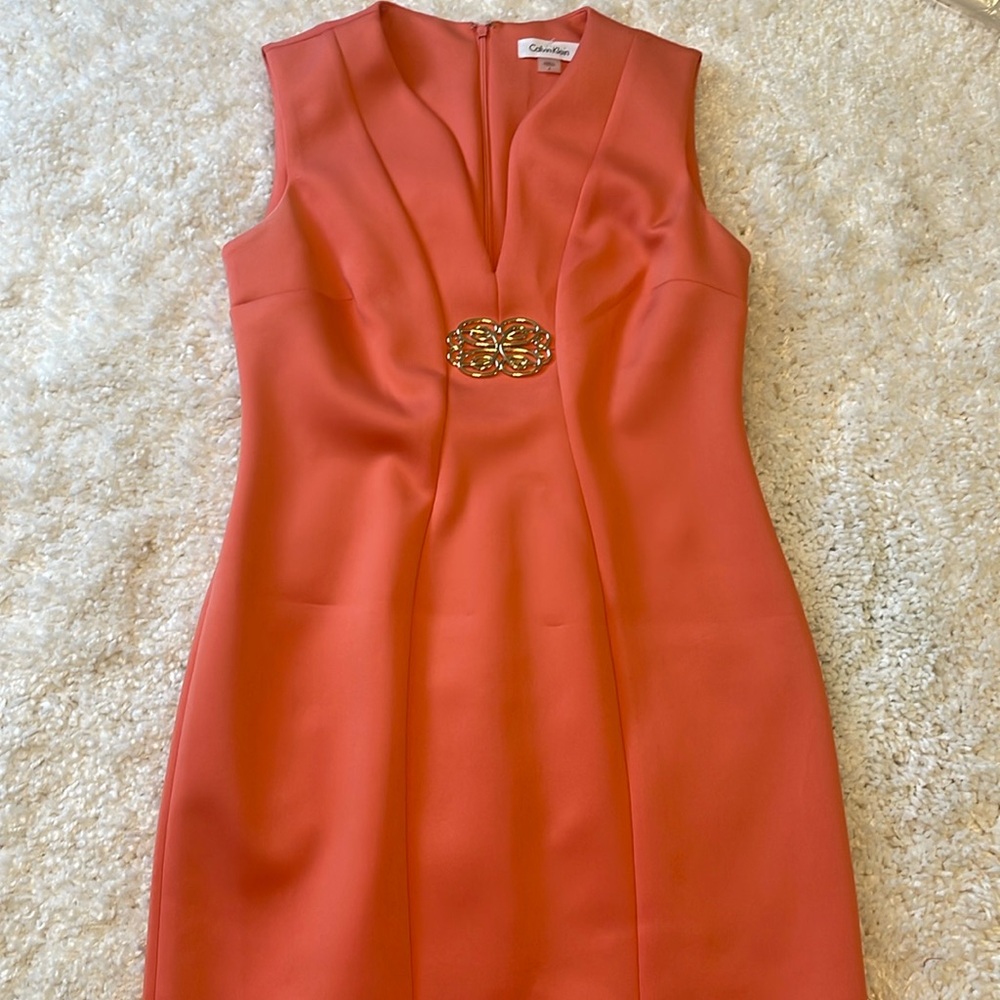 Brand new CK coral dress with gold attached brooch 95% polyester 5% spandex.